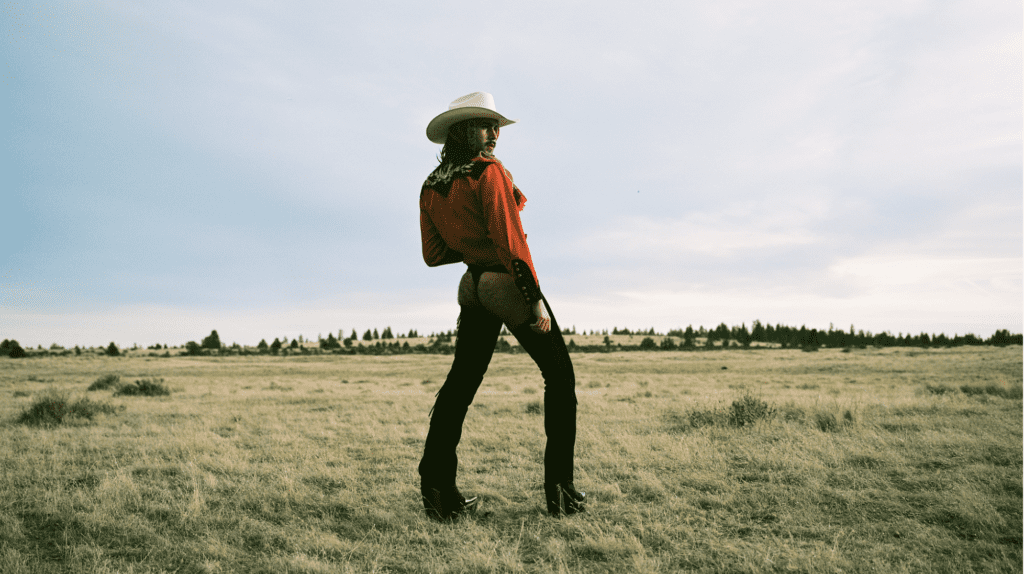 A cowboy looking away from the horizon.